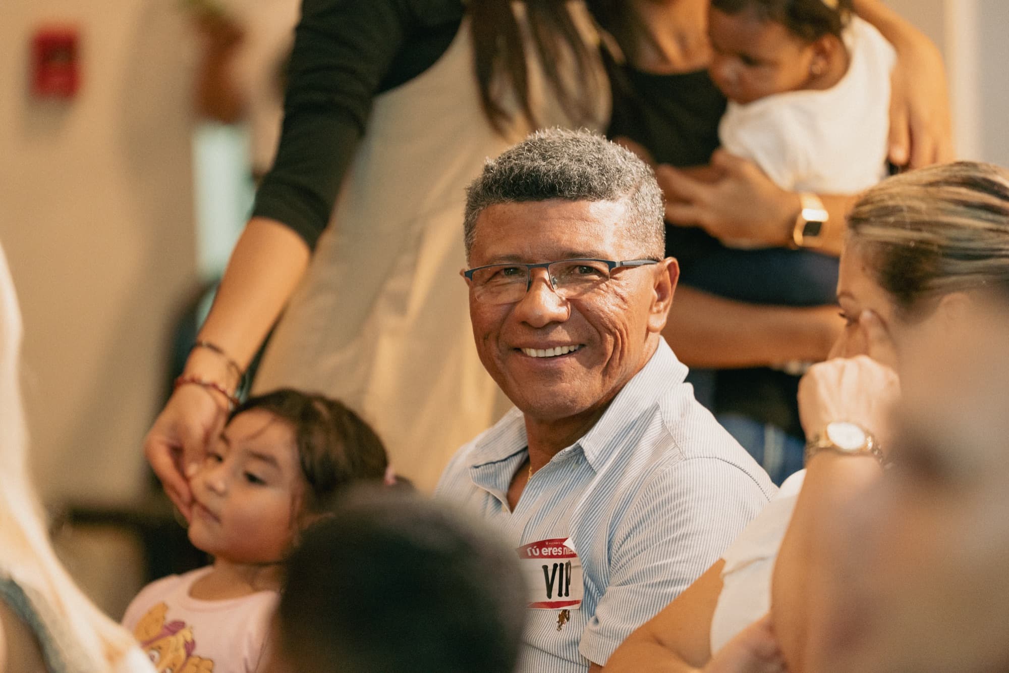 Miembro de la comunidad sonriendo junto a su familia